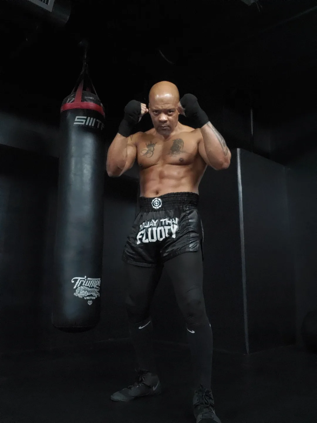 Coach Bizz in his Muay Thai guard next to the heavy bag