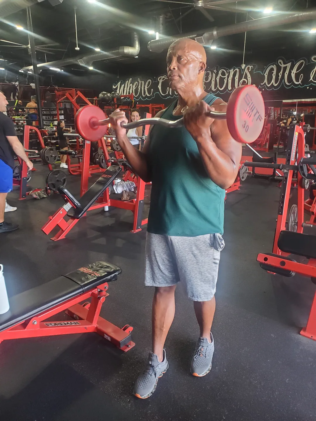Coach Bizz curling the EZ bar — leading by example